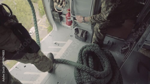 a soldier in a helmet and combat armor participates in a military helicopter operatio photo