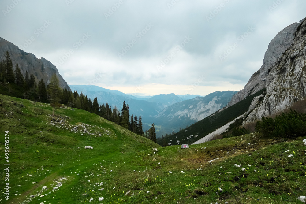 Obraz premium Hiking trail over alpine meadow leading to the mountain hut on the Haueslalm in the Hochschwab Region in Upper Styria, Austria. Early spring in the beautiful Alps in Europe. Hike tourism, wilderness