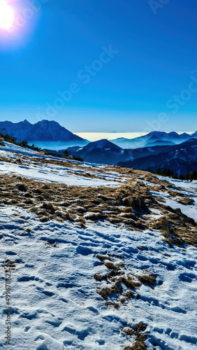 Panoramic view on snow capped mountain peaks of Karawanks in Carinthia, Austria. Julian Alps. Winter wonderland in the Austrian Alps, Europe. Ski tour, snow shoe hiking. Hochobir. Blue misty hills. photo