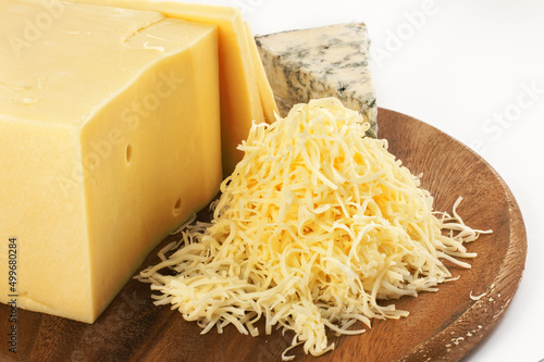 Garganzola cheese and freshly grated parmesan cheese on a wooden table.