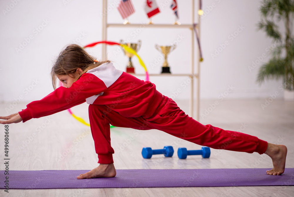 Young little girl doing sport exercises at home Stock Photo | Adobe Stock