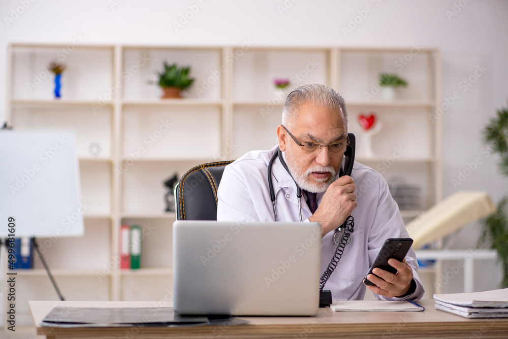 Old male doctor in telemedicine concept