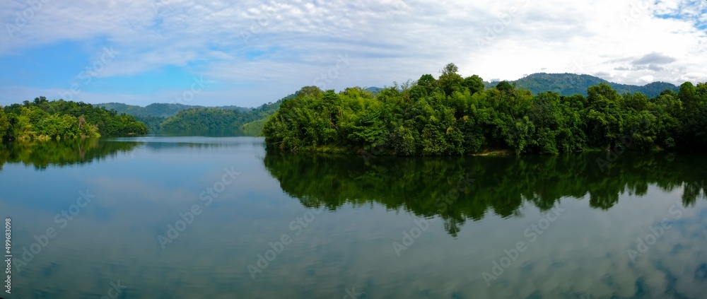 Fototapeta premium Panoramic view of dam water surrounded with green trees in Kuala Kubu Bharu, Selangor, Malaysia.