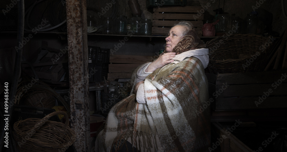 Fototapeta premium Frightened woman hide from explosions in the basement. During the sirens due to the shelling of Kyiv. Ukraine. 26 February 2022