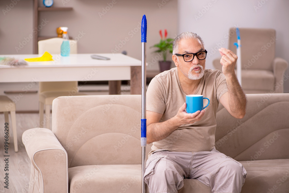 Old man doing housework at home Old man doing housework at home
