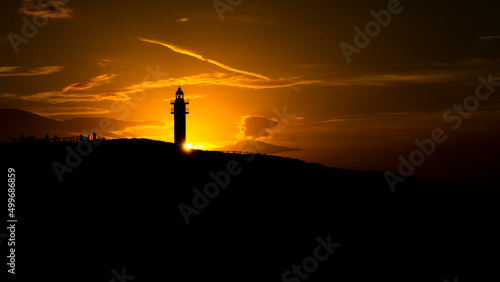 silhouette at sunset in ajo lighthouse with sun rays