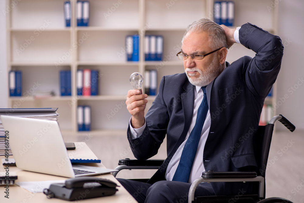 Old male employee in wheel-chair in happy idea concept Old male employee in wheel-chair in happy idea concept