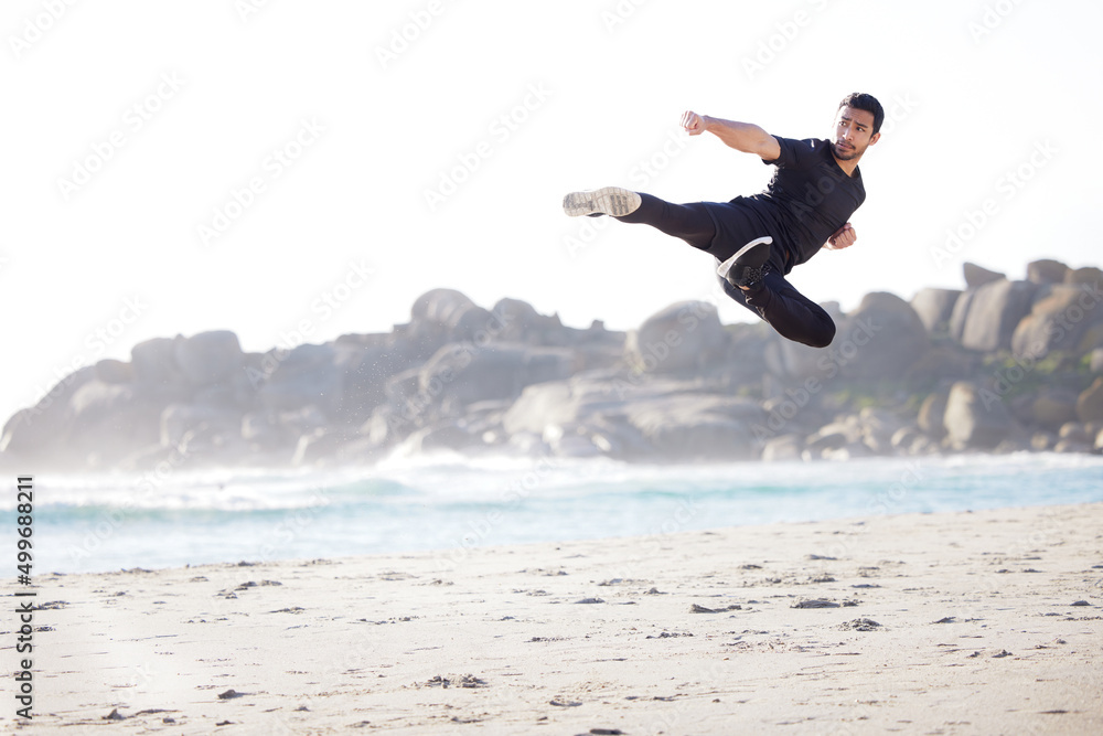 Flying through his fitness routine. Full length shot of a handsome young male athlete working out on the beach. Flying through his fitness routine. Full length shot of a handsome young male athlete working out on the beach.
