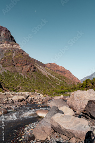 Vertical view of colorful mountains with vegetation and river in the Cajón del Maipo, Chile. photo