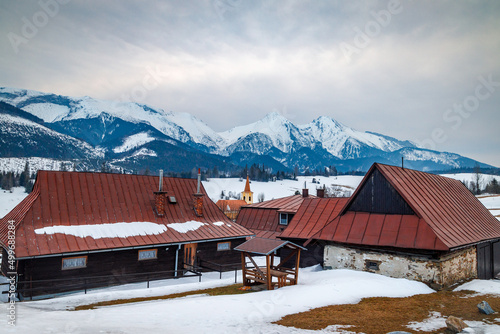 Folk architecture of the distinctive village of Zdiar with a panorama of mountains in the background at winter. High Tatras National Park, Slovakia, Europe. photo