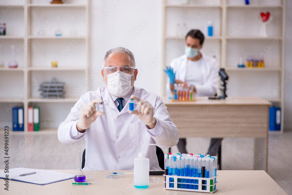 Two male chemist working at the lab Two male chemist working at the lab