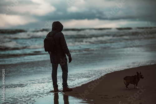 Fototapeta Naklejka Na Ścianę i Meble -  Baltic sea in winter time. A man with a dog. Hel, Poland