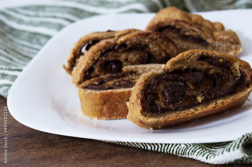 Sliced bread with chocolate swiss roll filling inside a white plate Sliced bread with chocolate swiss roll filling inside a white plate