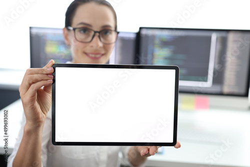 Woman is holding tablet with white screen. at work