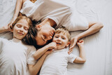 Mother with son and daughter having fun in bed