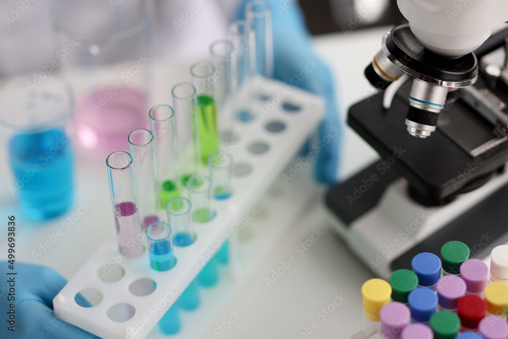 Fototapeta premium Multicolored laboratory test tubes and microscope in laboratory