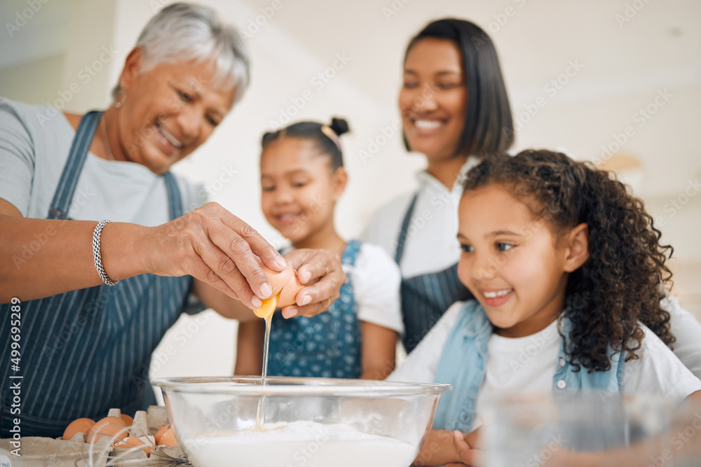 The eggs make it extra fluffy. Shot of a multi-generational family baking together at home.