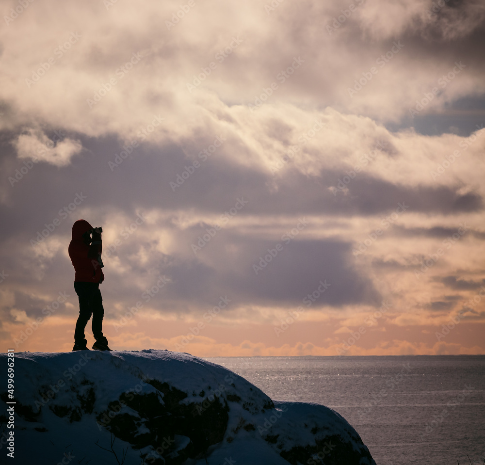 silhouette of a photographer standing on the top of the mountain