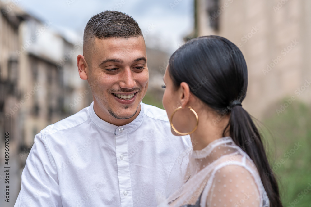 Smiling young man looking at his partner outdoors Smiling young man looking at his partner outdoors