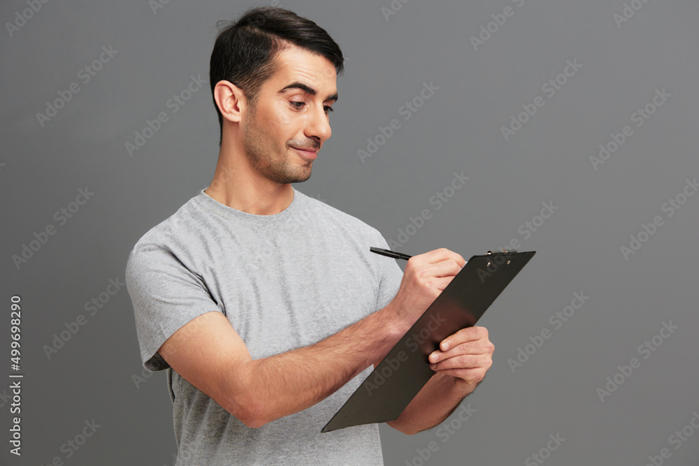 man folder for papers holding a pen posing lifestyle Gray background man folder for papers holding a pen posing lifestyle Gray background
