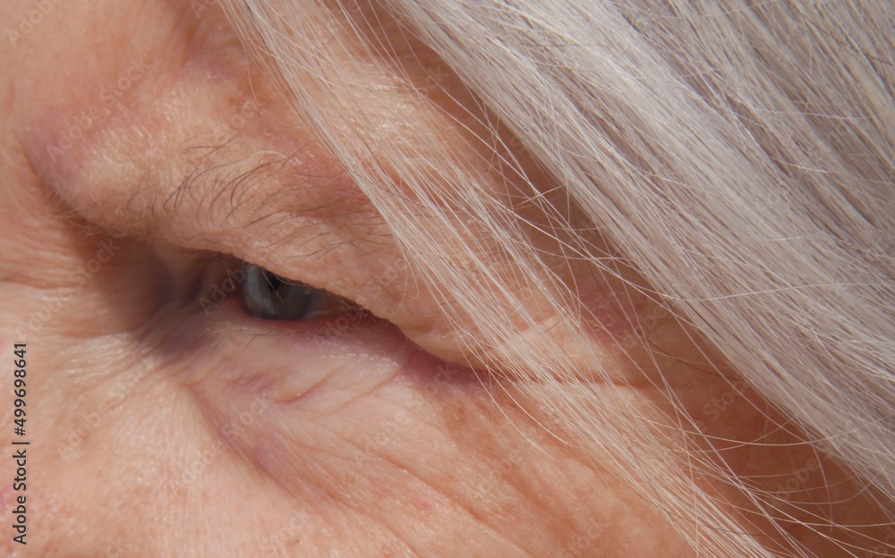 Portrait d'une femme âgée regardant au loin. Gros plan sur l'œil et les cheveux. Concept de l'âge Portrait d'une femme âgée regardant au loin. Gros plan sur l'œil et les cheveux. Concept de l'âge