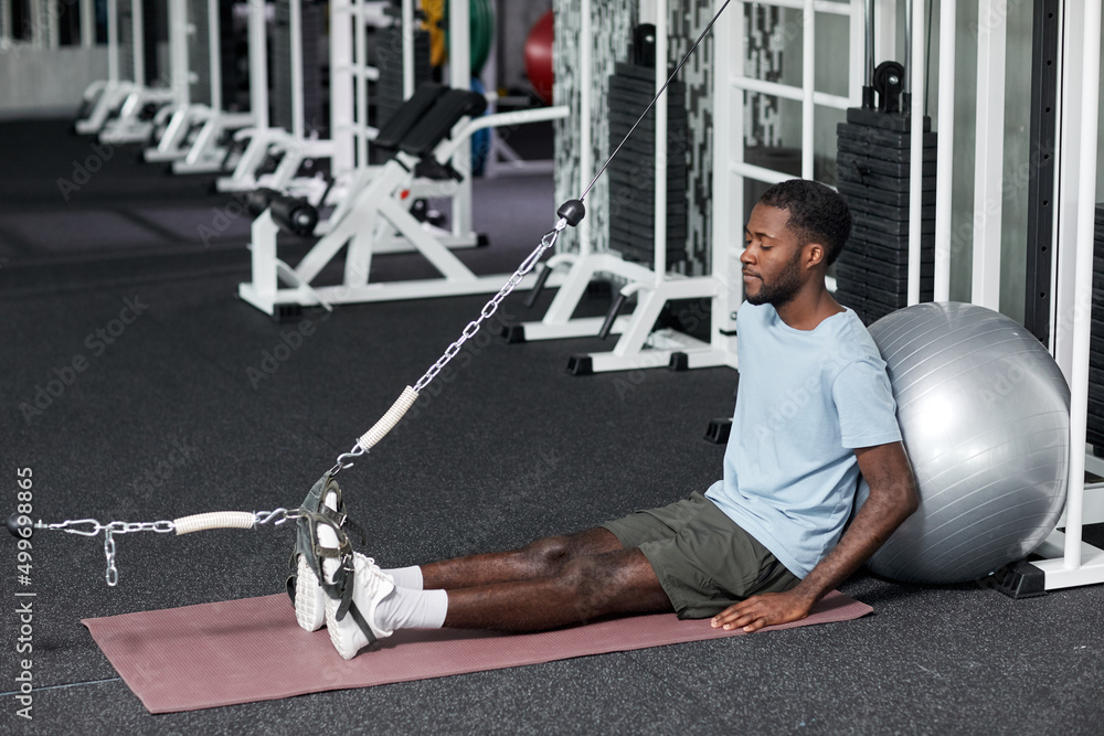 Portrait of black young man doing rehabilitation exercises in gym at clinic, copy space Portrait of black young man doing rehabilitation exercises in gym at clinic, copy space