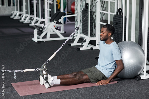 Portrait of black young man doing rehabilitation exercises in gym at clinic, copy space