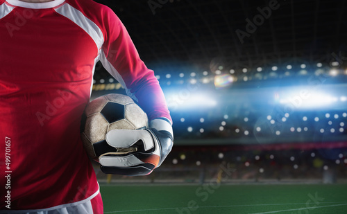 Goalkeeper holds the ball in the stadium during a football game © alphaspirit