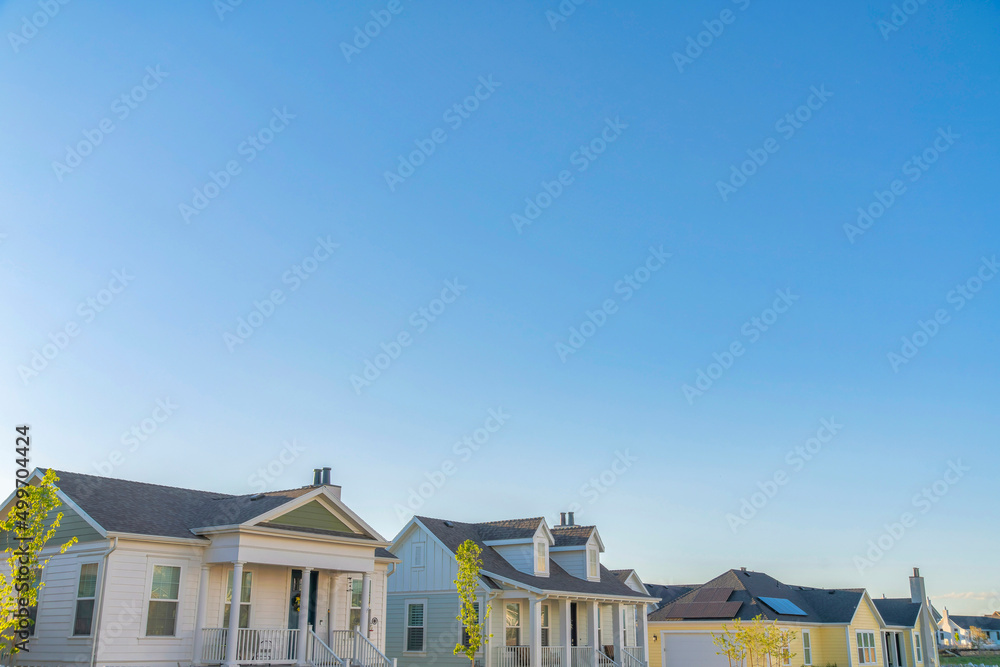 Two white and two yellow houses with traditional design at Daybreak, South Jordan, Utah