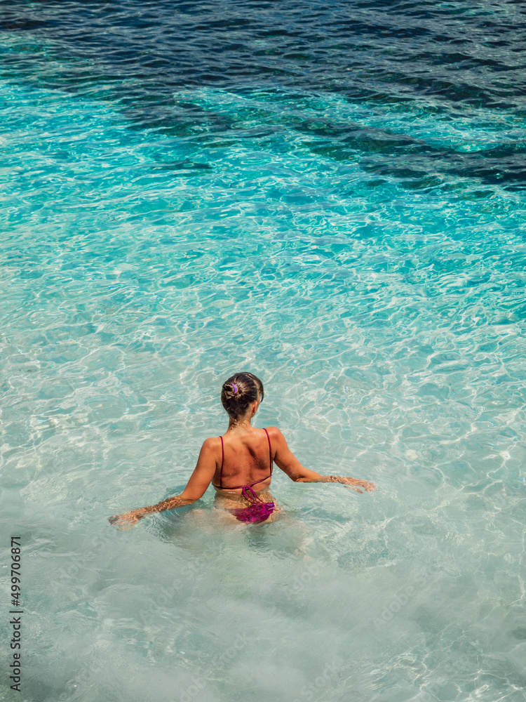 Attractive woman, bikini girl swim in tropical ocean