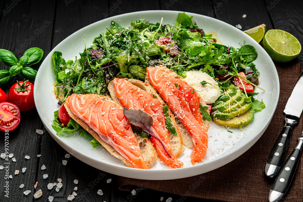 Salted salmon on croutons with fresh salad and parmesan cheese Salted salmon on croutons with fresh salad and parmesan cheese