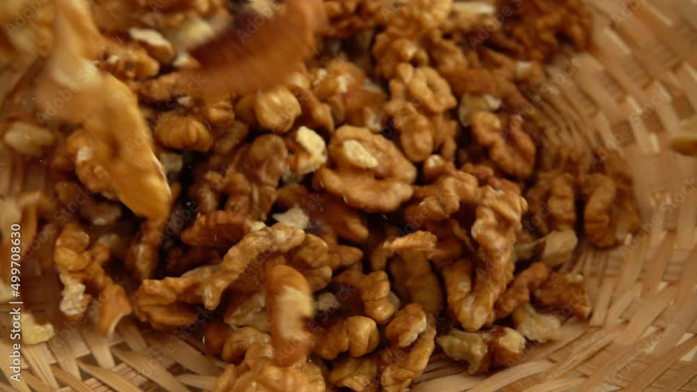 Walnut kernels fall into a wicker basket. Slow motion. Walnut kernels fall into a wicker basket. Slow motion.
