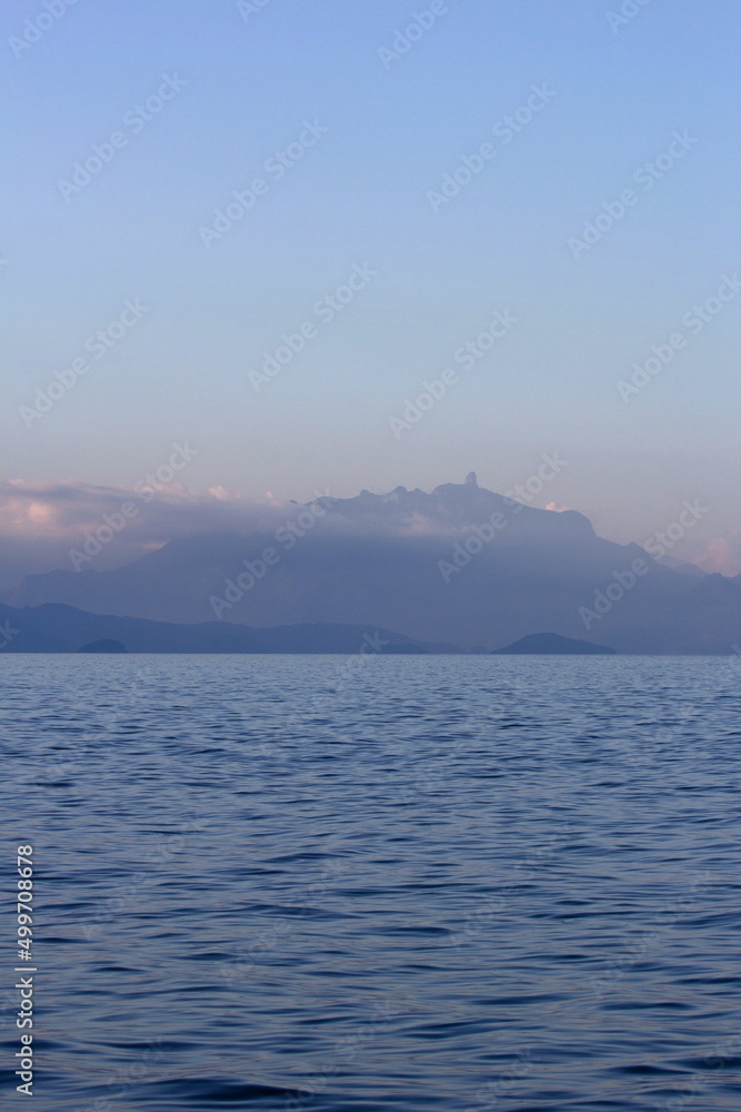 Relaxing sea landscape, sky with mountains on the horizon. Texture, background design feature ideal for social media posts, relaxing image, peaceful moment. Ocean, immensity, infinite water.