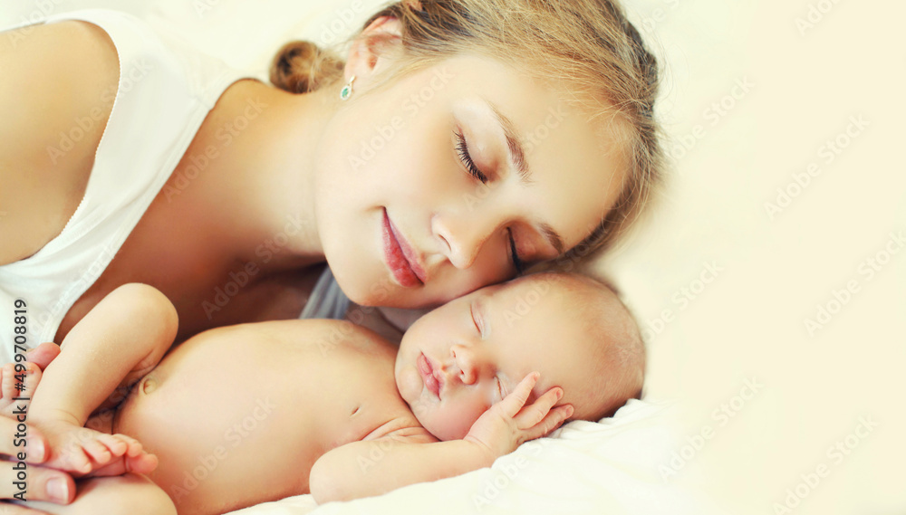 Portrait of sleeping mother and baby lying on the bed together at home Portrait of sleeping mother and baby lying on the bed together at home
