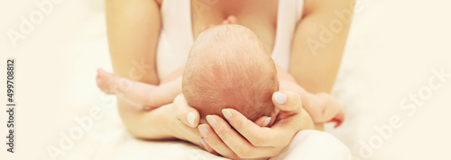Obraz na plátně Portrait close up of baby infant sleeping on mother's hands on white background