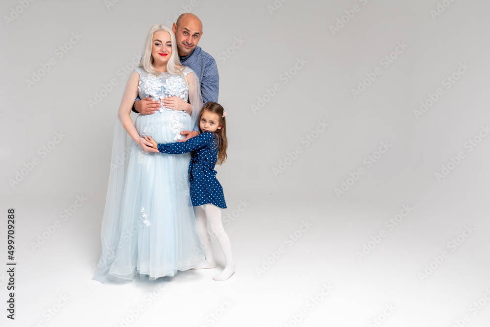 Beautiful pregnant woman with her family on light background Beautiful pregnant woman with her family on light background