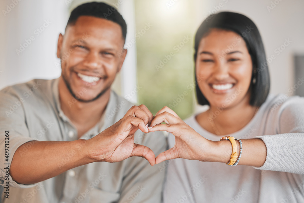 Fototapeta premium It takes someone special to catch your heart. Portrait of a young couple making a heart shape with their hands at home.