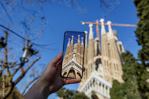 Taking photos of Sagrada Familia with a mobile phone camera. Travel to Barcelona, Spain. photo