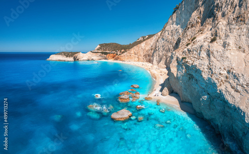 Fototapeta Naklejka Na Ścianę i Meble -  Aerial view of blue sea, rocks, sandy beach with people at sunset