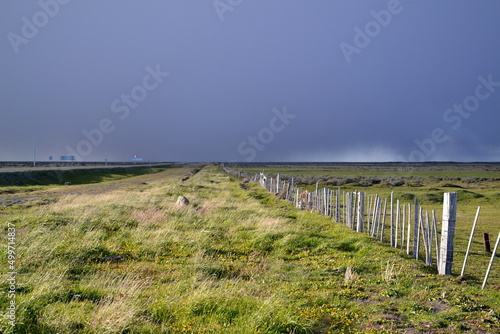 Patagonian road in Chili with farm lands called estancia with green grass and blue dark sky. High quality photo