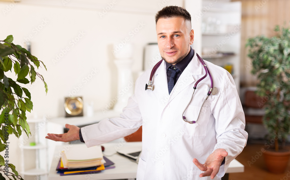Portrait of confident young male doctor working at medical office