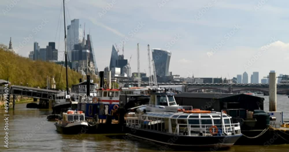 Looking up to the City of London over floating Boats on the River of Thames, London, United Kingdom Looking up to the City of London over floating Boats on the River of Thames, London, United Kingdom