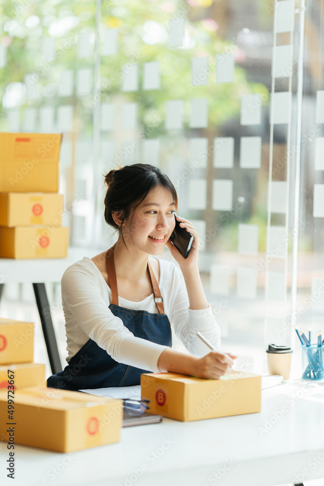 Successful Asian women entrepreneur with parcel boxes in her own job shopping online business at home office. start up small business, sme concept. Successful Asian women entrepreneur with parcel boxes in her own job shopping online business at home office. start up small business, sme concept.