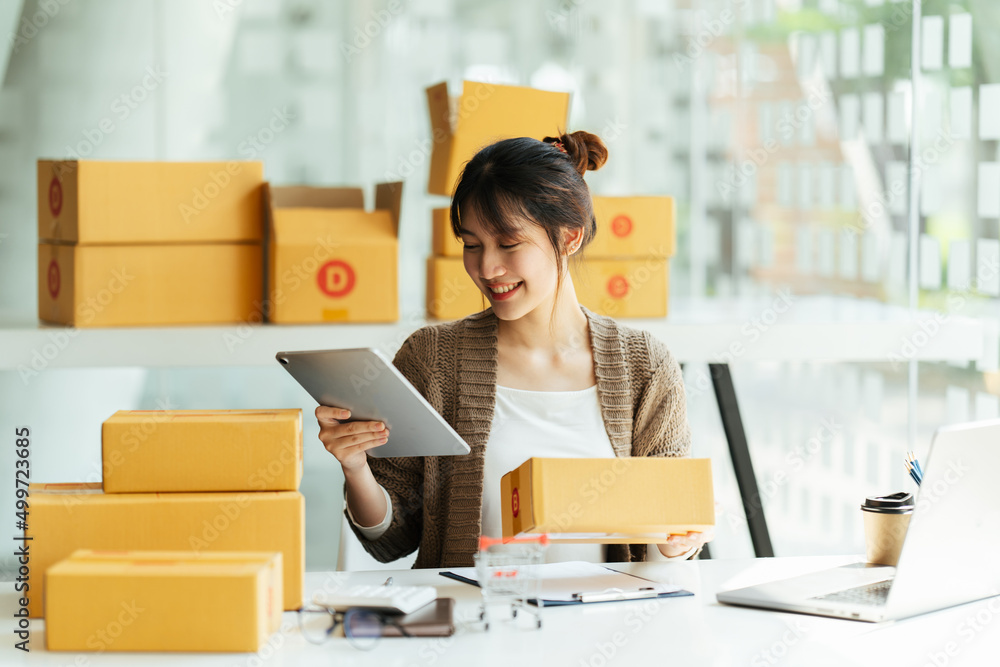 Successful Asian women entrepreneur with parcel boxes in her own job shopping online business at home office. start up small business, sme concept. Successful Asian women entrepreneur with parcel boxes in her own job shopping online business at home office. start up small business, sme concept.