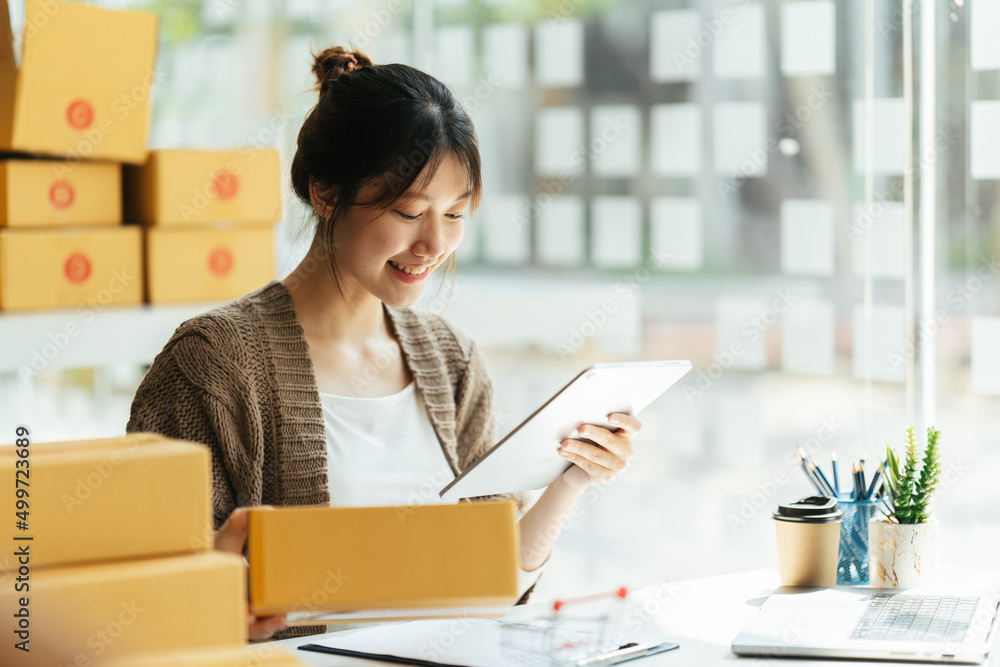 Successful Asian women entrepreneur with parcel boxes in her own job shopping online business at home office. start up small business, sme concept. Successful Asian women entrepreneur with parcel boxes in her own job shopping online business at home office. start up small business, sme concept.