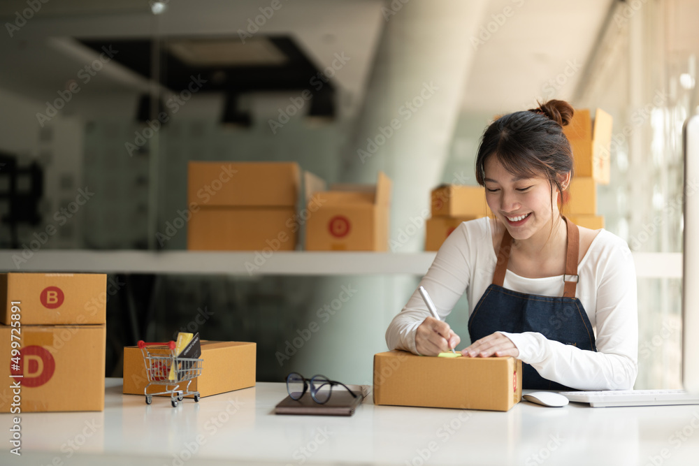 Startup SME small business entrepreneur of freelance asian woman using a laptop with box Cheerful success online marketing packaging box and delivery SME idea concept. Startup SME small business entrepreneur of freelance asian woman using a laptop with box Cheerful success online marketing packaging box and delivery SME idea concept.