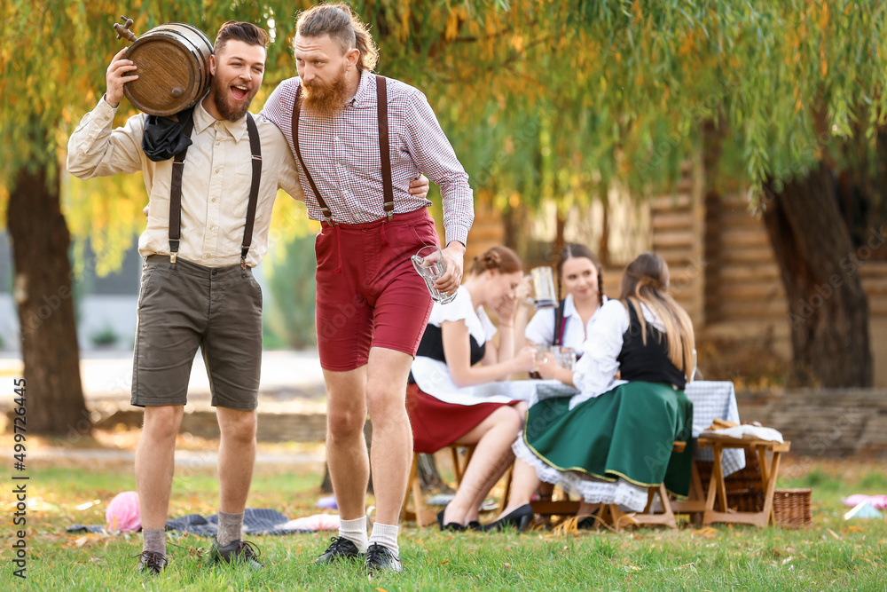 Fototapeta premium Drunk men with beer celebrating Octoberfest outdoors