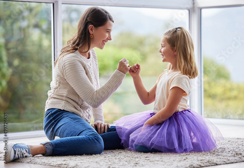 This promise will never be broken. Shot of a young mother and daughter making a pinky promise at home. photo