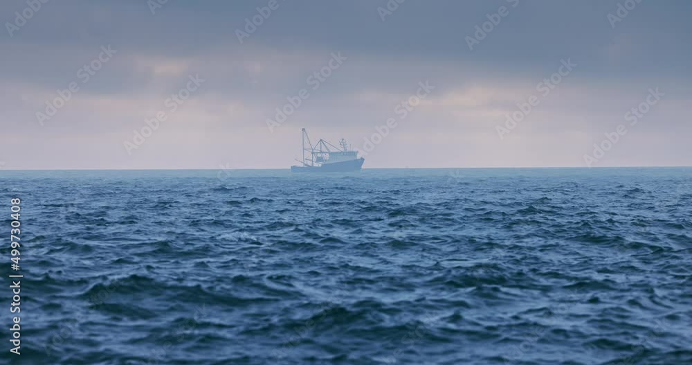 Fog above blue ripple sea with ripple waves and sailing ship boat, dusk over waves Fog above blue ripple sea with ripple waves and sailing ship boat, dusk over waves