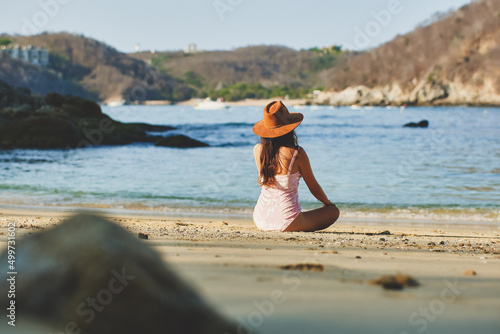 Latin woman sitting on the beach, enjoying the sunset. Woman reading book. Woman on the beach of Huatulco Oaxaca. relaxed young woman. Background cruise. Happy woman on vacation in Mexico. Resting in 